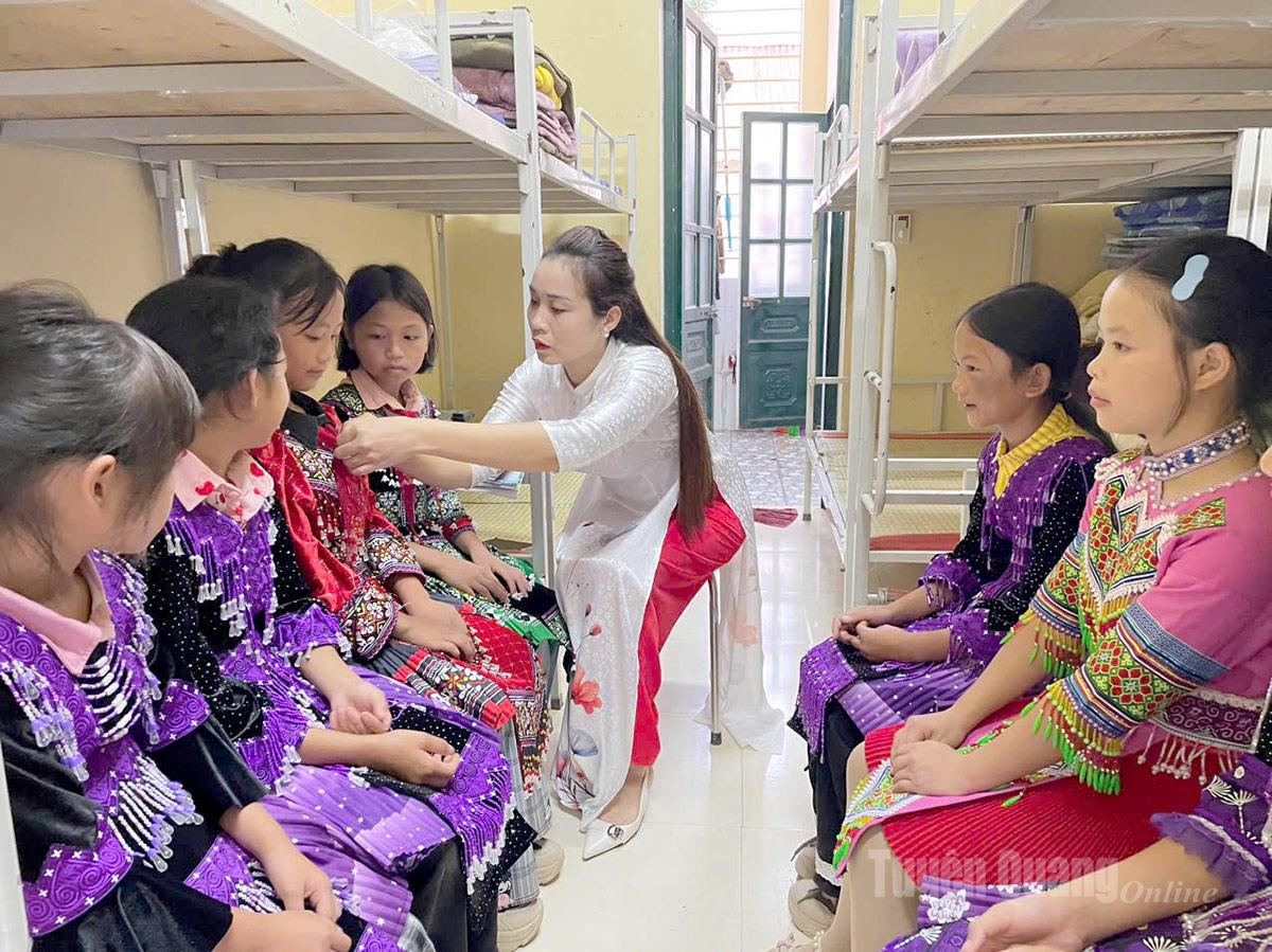 Cô giáo trường Phổ thông Dân tộc bán trú Tiểu học và THCS Xuân Lập, xã Lâm Bình chỉnh trang phục cho các em học sinh để chuẩn bị dự Lễ khai giảng. Ảnh Minh Hoa