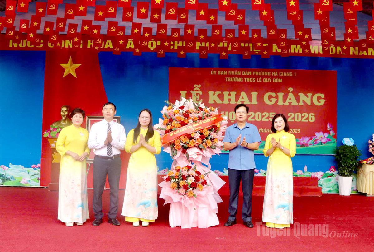 Đồng chí Trần Quang Minh, Uỷ viên Ban Thường vụ Tỉnh ủy, Chủ nhiệm Uỷ ban Kiểm tra Tỉnh ủy tặng hoa chúc mừng khai giảng năm học mới trường THCS Lê Quý Đôn (phường Hà Giang 1). Ảnh: Khánh Huyền