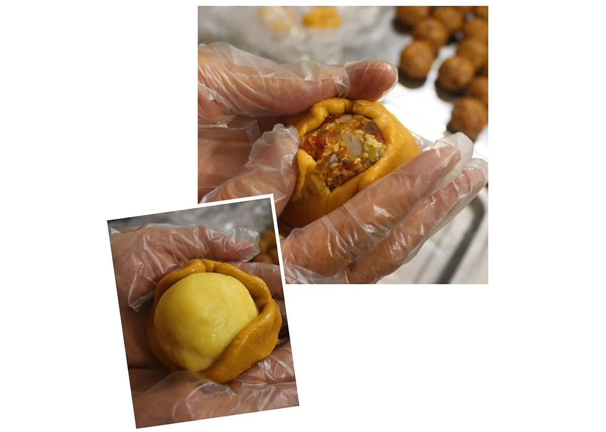 The step of wrapping the dough around the filling requires meticulous care to prevent the filling from leaking before the cake is placed into the mold.
