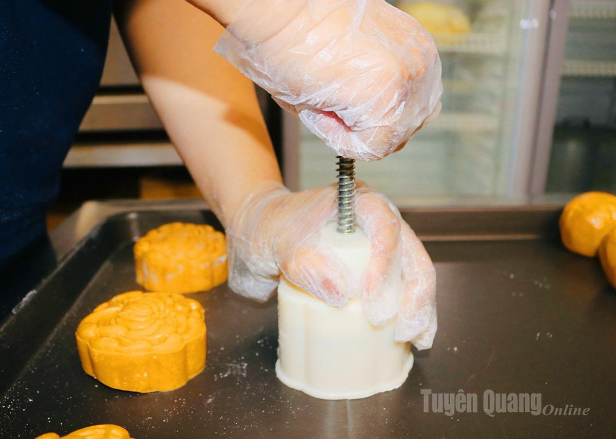 After filling, the baker presses the cake into the mold for shaping. Nowadays, to ensure food safety and hygiene, Mrs. Lam’s family has replaced traditional wooden molds with cleaner, more convenient plastic ones.