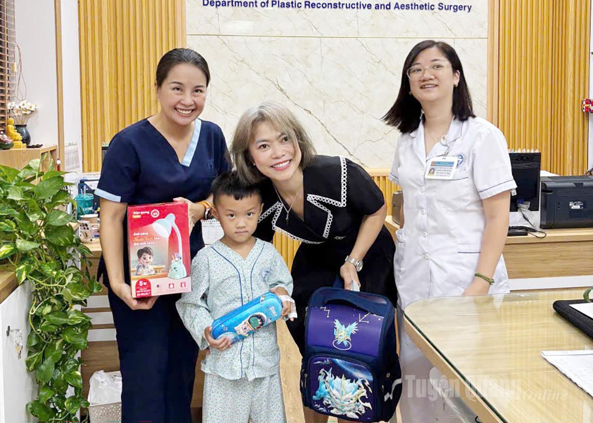 Bác sỹ chia vui, tặng quà cho bé Long sau ca phẫu thuật bàn tay thành công.