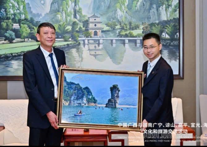 Đồng chí Lê Thanh Sơn, Phó Giám đốc Sở Văn hoá, Thể thao và Du lịch tỉnh Tuyên Quang (Việt Nam) tặng bức tranh phong cảnh Na Hang cho đồng chí Hàn Lưu, Bí thư Đảng ủy Sở Văn hoá và Du lịch Quảng Tây (Trung Quốc).