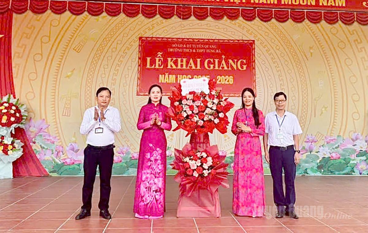 Đồng chí Âu Thị Mai, Ủy viên BCH Đảng bộ tỉnh, Phó Chủ tịch Ủy ban MTTQ tỉnh, Chủ tịch Hội Liên hiệp Phụ nữ tỉnh tặng hoa chúc mừng trường THCS & THPT Tùng Bá, xã Tùng Bá. Ảnh: Thuý Nga