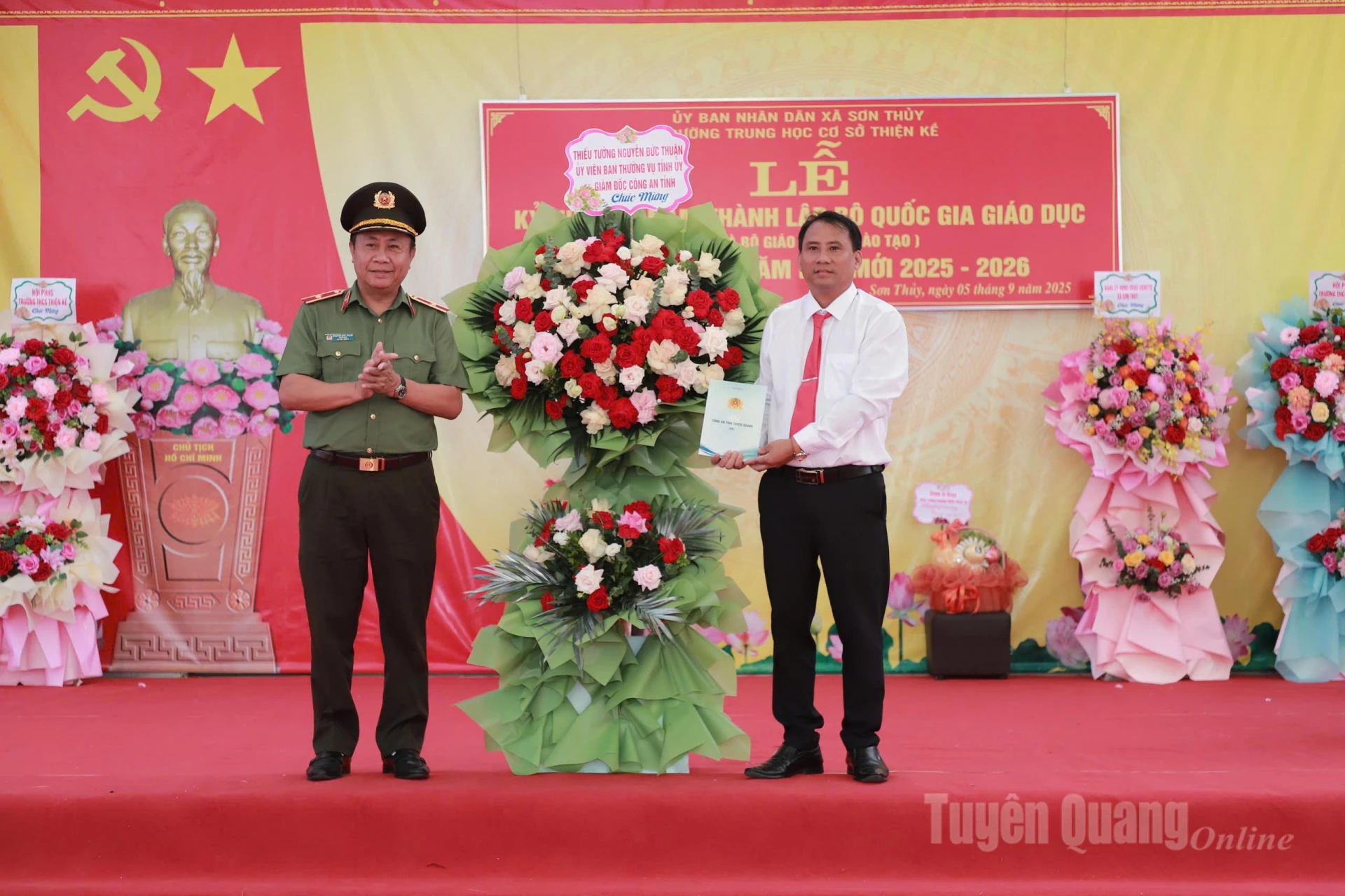 Thiếu tướng Nguyễn Đức Thuận, Ủy viên Ban Thường vụ Tỉnh ủy, Bí thư Đảng ủy, Giám đốc Công an tỉnh Tuyên Quang tặng lẵng hoa chúc mừng trường THCS Thiện Kế, xã Sơn Thủy nhân dịp khai giảng năm học mới. Ảnh: Phi Anh