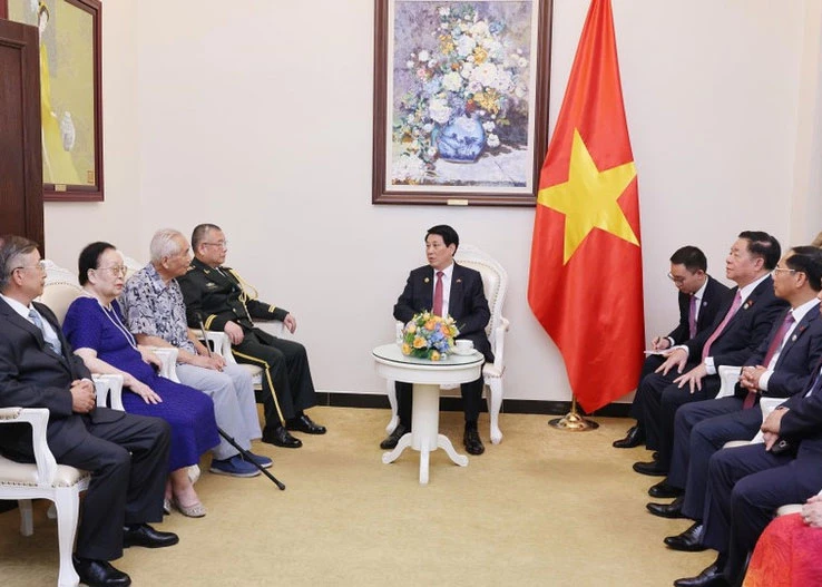 The September 4 meeting between President Luong Cuong (centre) and representatives of families of former Chinese and Vietnamese experts, advisors, and officials. (Photo: VNA)