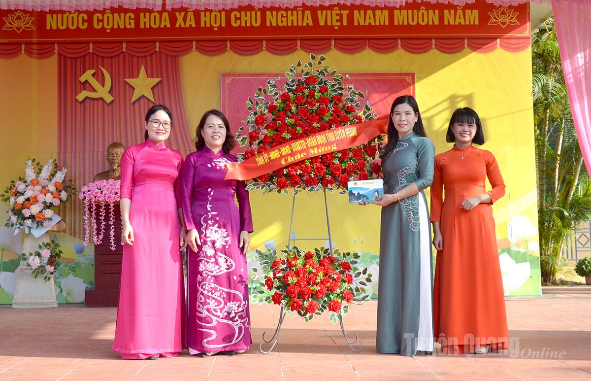 Đồng chí Lý Thị Lan, Ủy viên Ban Thường vụ Tỉnh uỷ, Trưởng đoàn Đại biểu Quốc hội tỉnh Tuyên Quang tặng hoa chúc mừng Trường THCS Tân Long.
