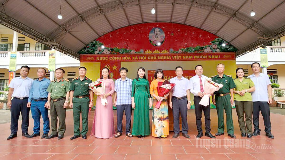 Đảng uỷ, HĐND, UBND và các lực lượng vũ trang xã biên giới Minh Tân tặng hoa chúc mừng trường PTDT bán trú THCS Minh Tân trong ngày khai giảng. Ảnh: Duy Tuấn