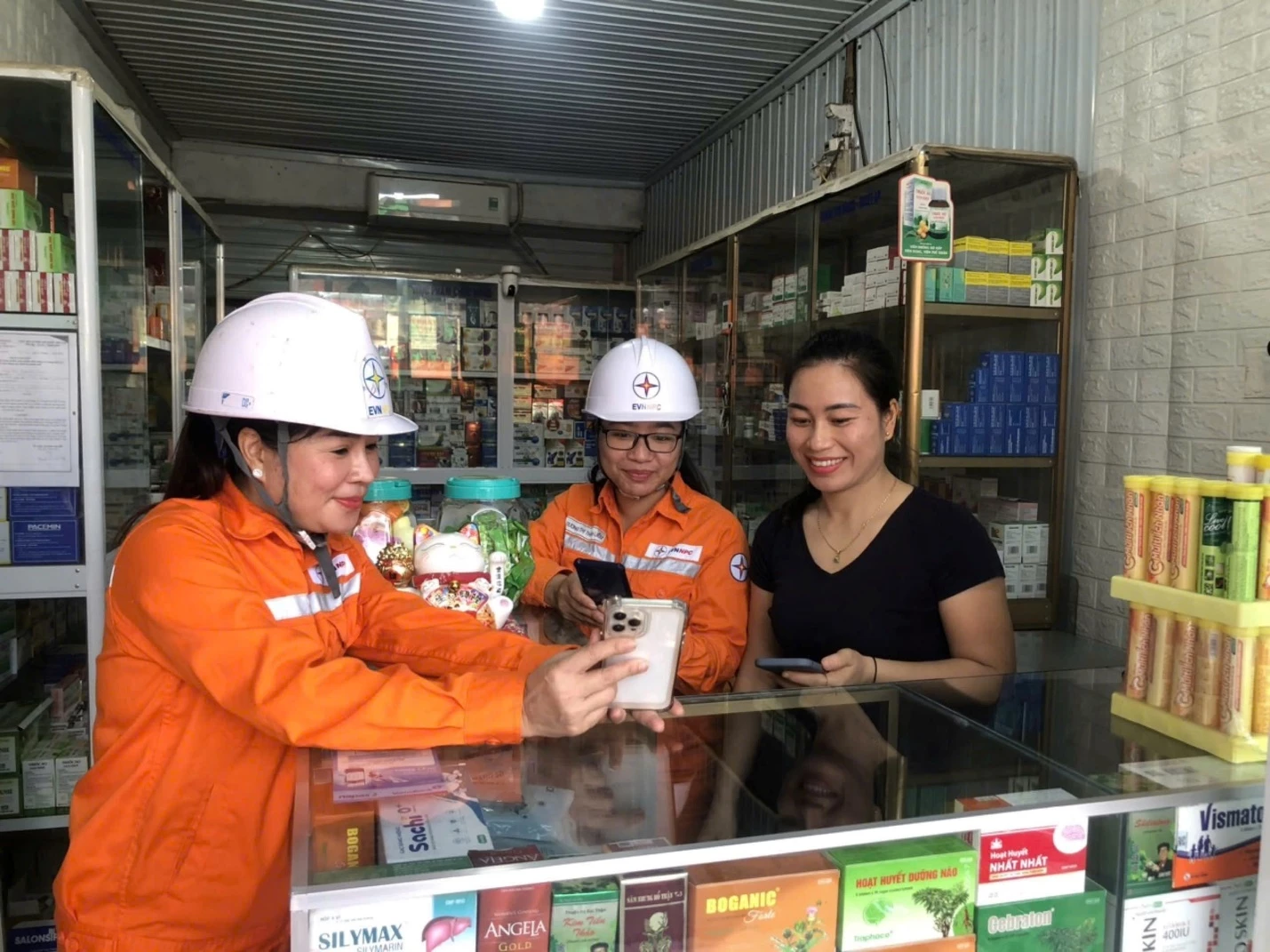 Cán bộ Công ty Điện lực Tuyên Quang hướng dẫn cho người dân sử dụng các dịch vụ điện trên điện thoại thông minh.