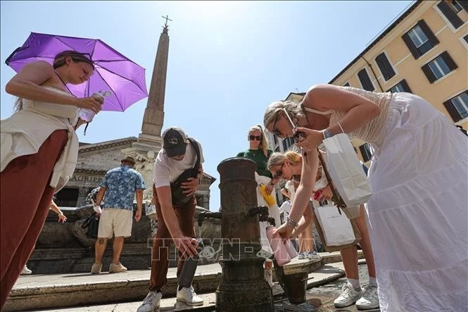 People get drinking water to cool down during a heatwave in Rome, Italy.