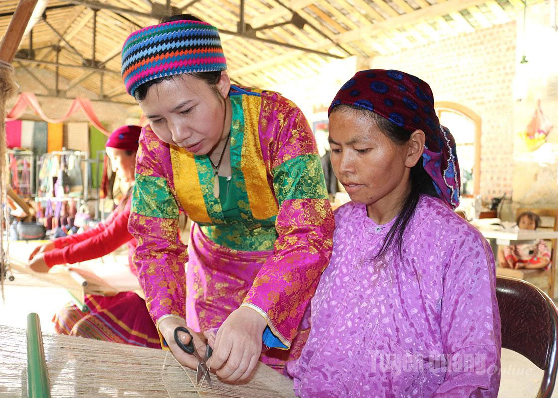 Ms. Vang Thi Cau carefully instructs members of the Sa Phin White Hemp Cooperative in hemp weaving skills.