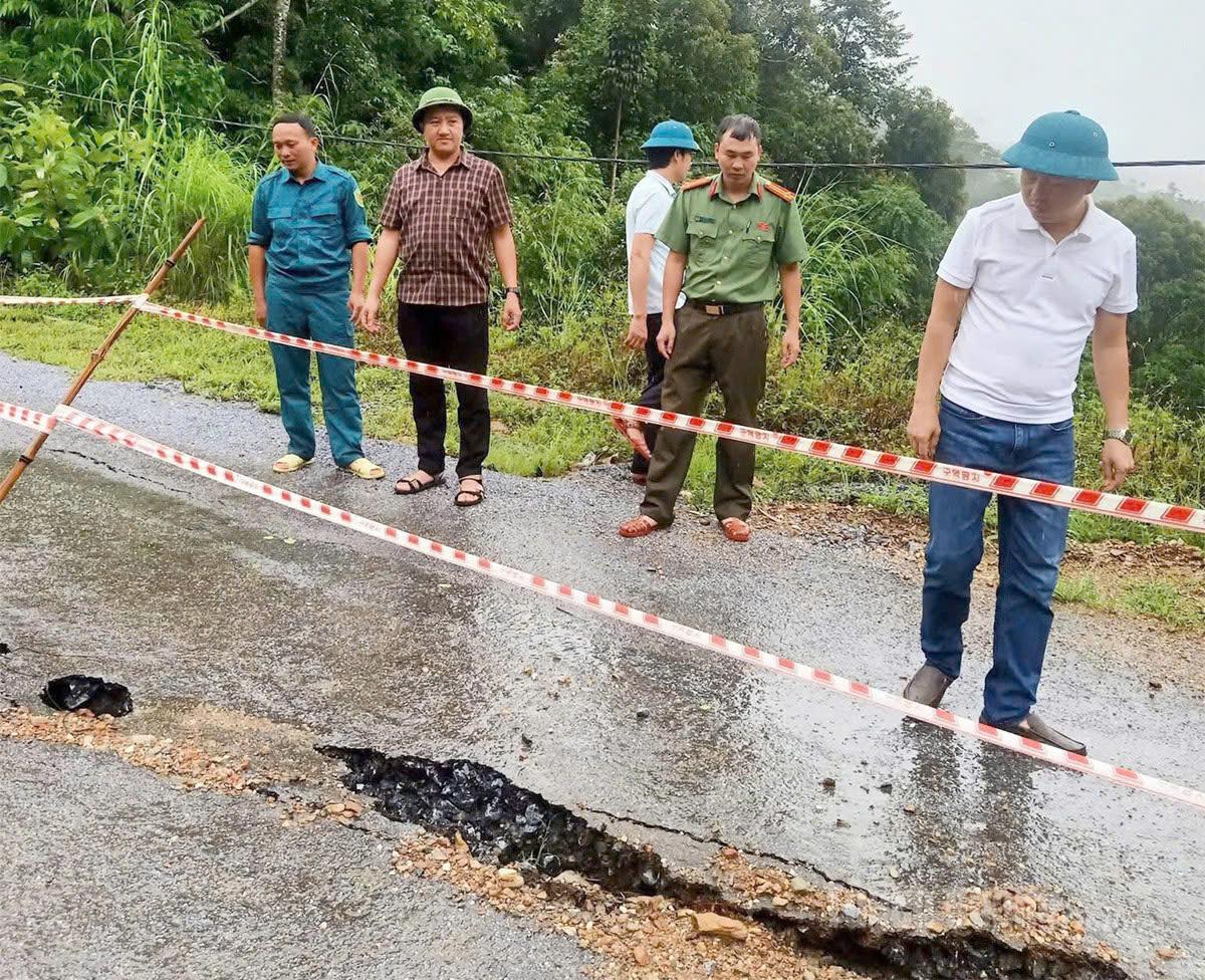 Lãnh đạo xã Thuận Hoà kiểm tra các vị trí xung yếu có nguy cơ ngập lụt, sạt lở và căng dây cảnh báo vết nứt đoạn qua thôn Lùng Pú trên đường đi xã Lùng Tám. Ảnh Khánh Huyền