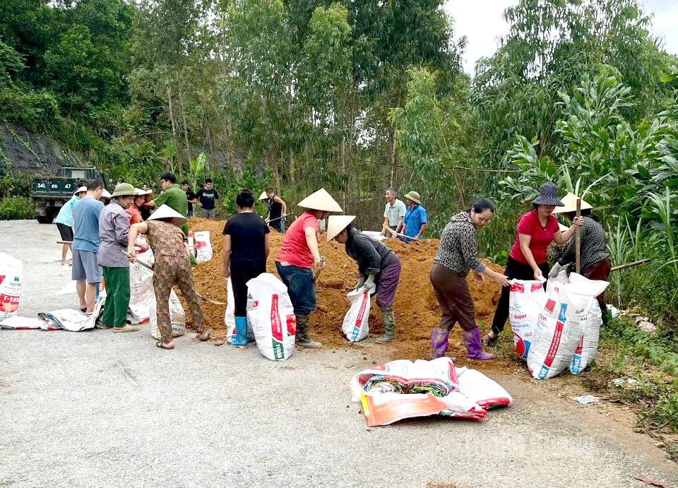 Lực lượng chức năng và nhân dân xã Hồng Sơn gia cố cống đê. Ảnh: Lý Thu