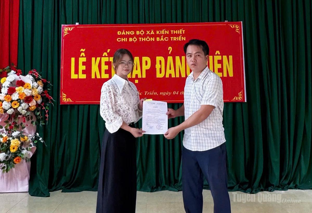 Đồng chí Hoàng Cao Thượng, Bí thư Chi bộ thôn Bắc Triển trao quyết định kết nạp đảng viên trẻ Phạm Quỳnh Ly.