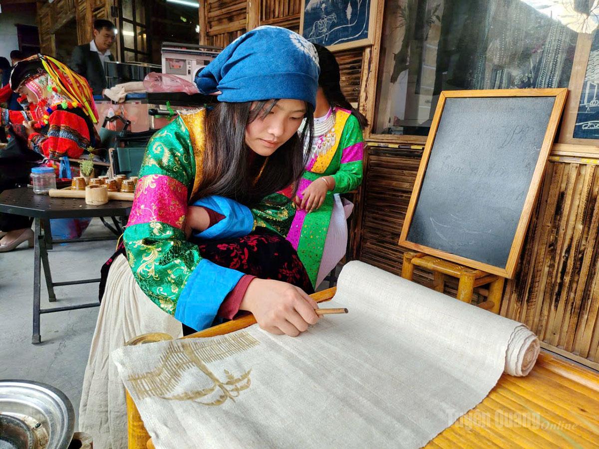 Du khách trải nghiệm vẽ sáp ong trên vải lanh tại làng nghề dệt lanh xã Lũng Cú. Ảnh: Văn Long.