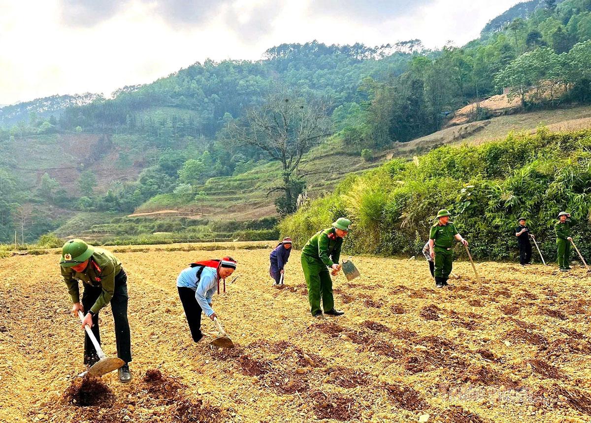 Cán bộ, chiến sĩ Công an xã Cán Tỷ cùng bà con làm đất trồng rau vụ đông.