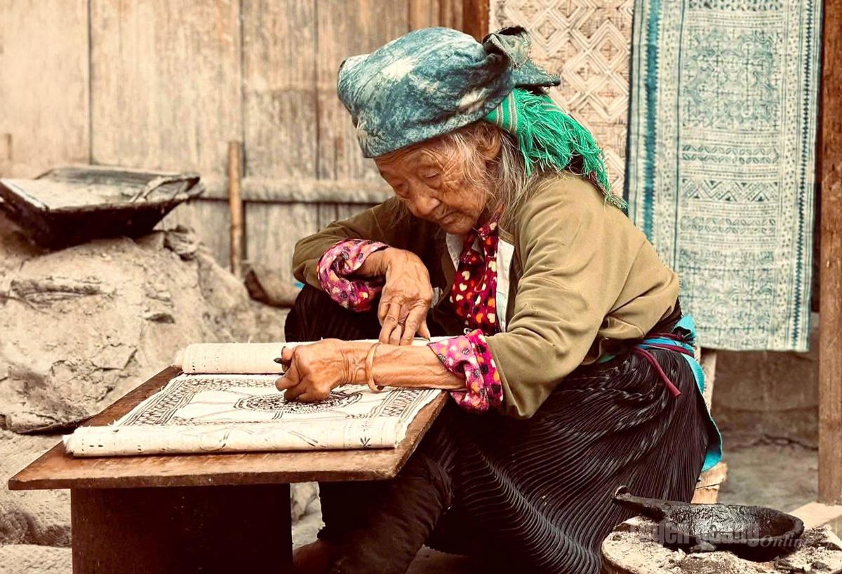  Nghệ nhân 
Sùng Thị Cở, 97 tuổi, 
miệt mài vẽ sáp ong trên vải lanh, 
gìn giữ nghề 
truyền thống.