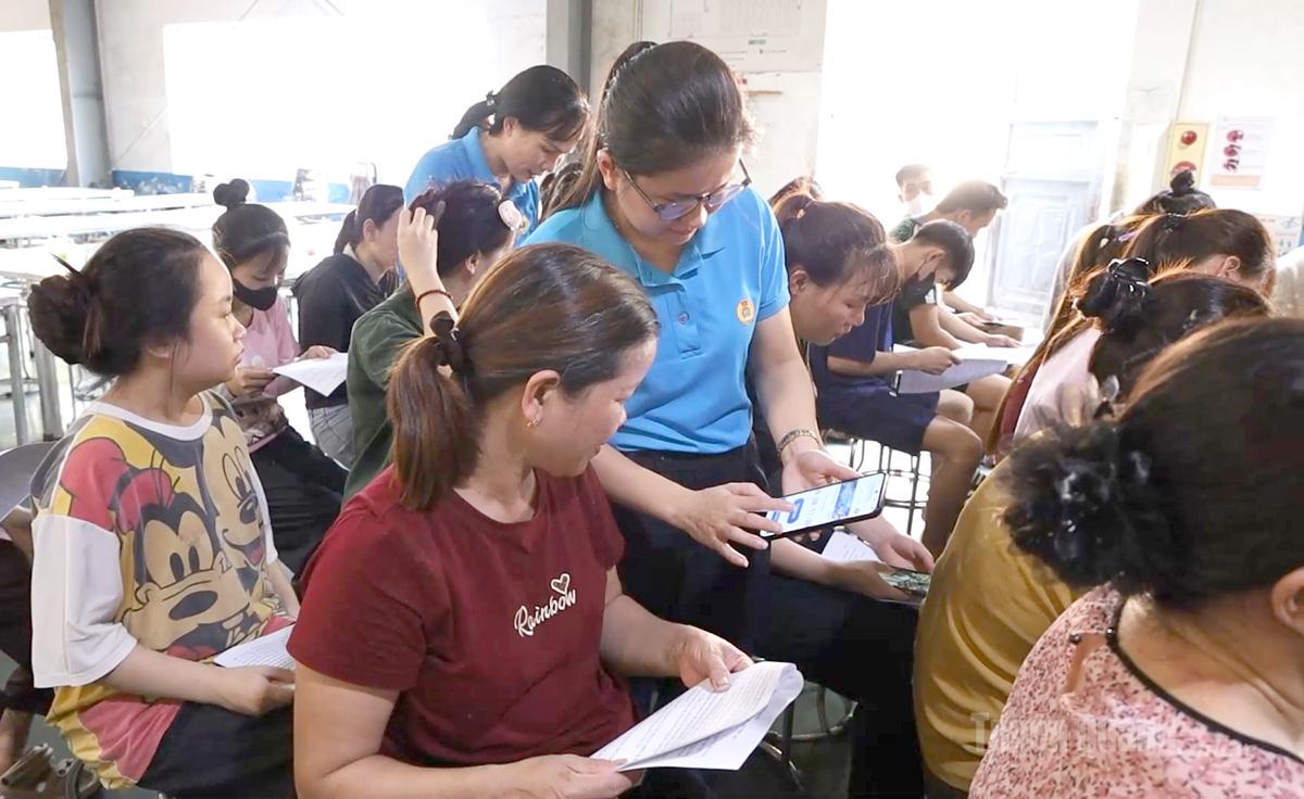 Công nhân lao động được hướng dẫn sử dụng ứng dụng trên điện thoại thông minh.
