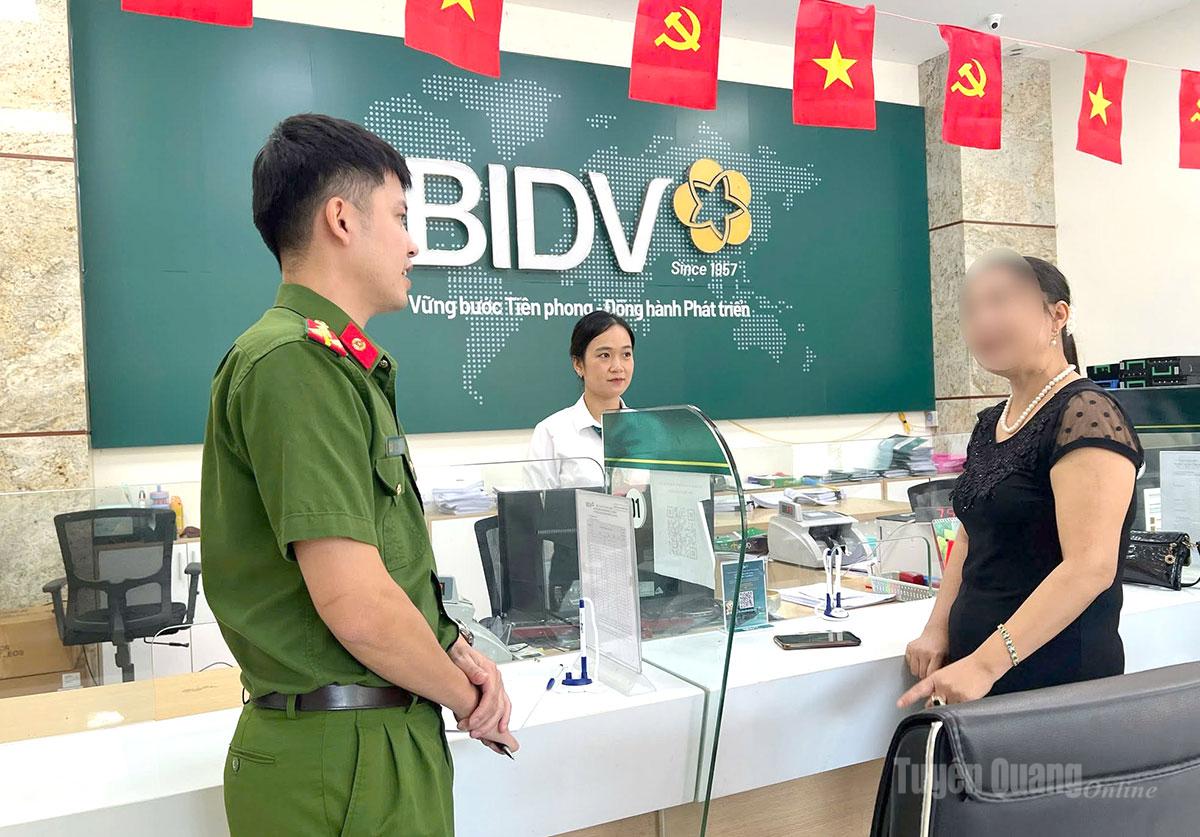 Cán bộ Công an xã Vị Xuyên và BIDV Phòng giao dịch Vị Xuyên tuyên truyền, giải thích cho chị L.T.H.H về các hình thức lừa đảo qua mạng.