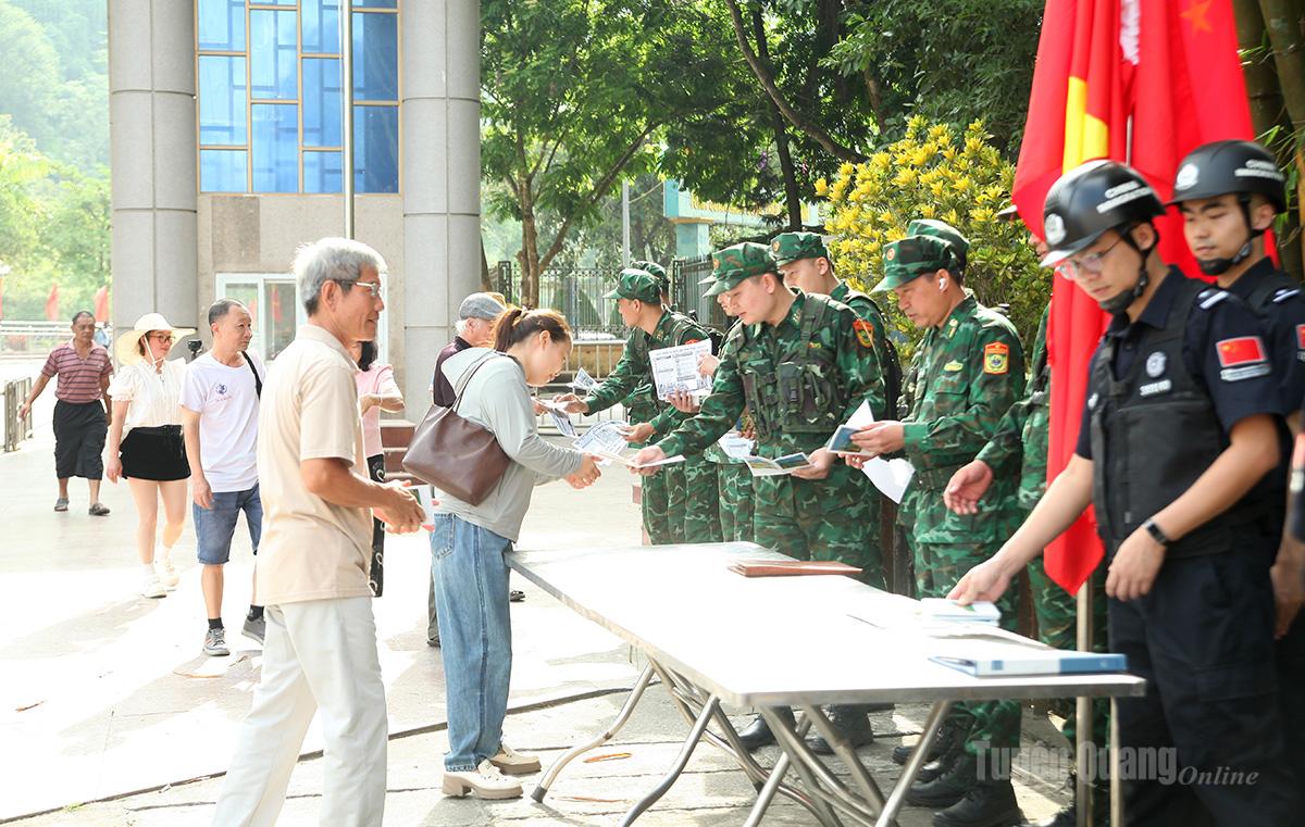 Các lực lượng phát tờ rơi tuyên truyền pháp luật cho cư dân qua lại cửa khẩu.