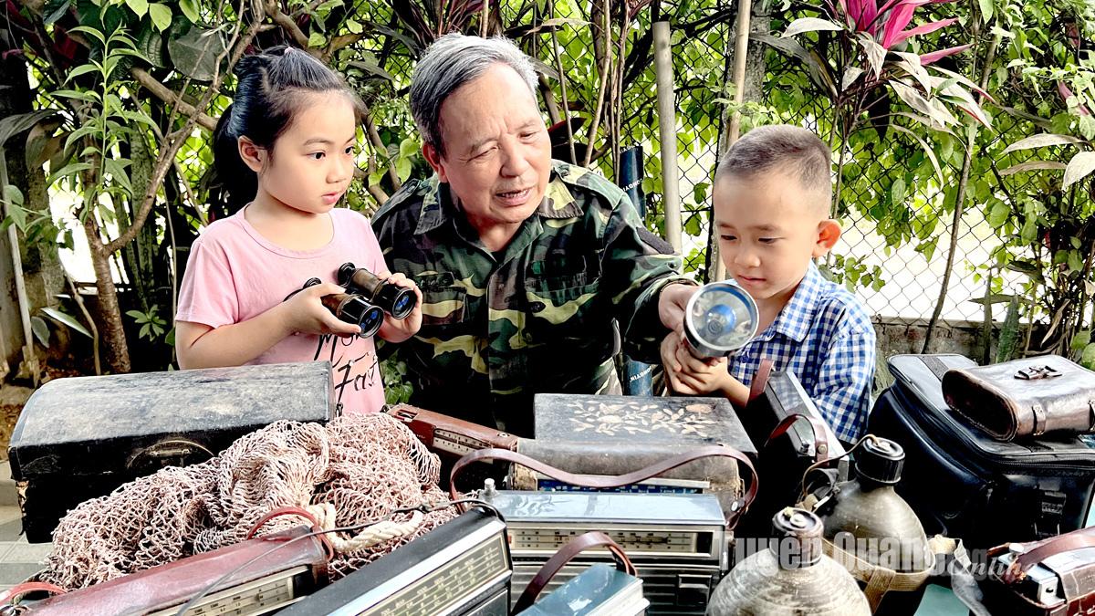 Ông Nguyễn Quang Vĩnh, xã Yên Nguyên kể câu chuyện chiến tranh qua kỷ vật cho các cháu mình.