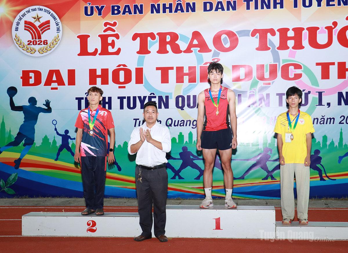 Ban tổ chức trao giải cho các vận động viên đoạt giải ở nội dung chạy 100m.