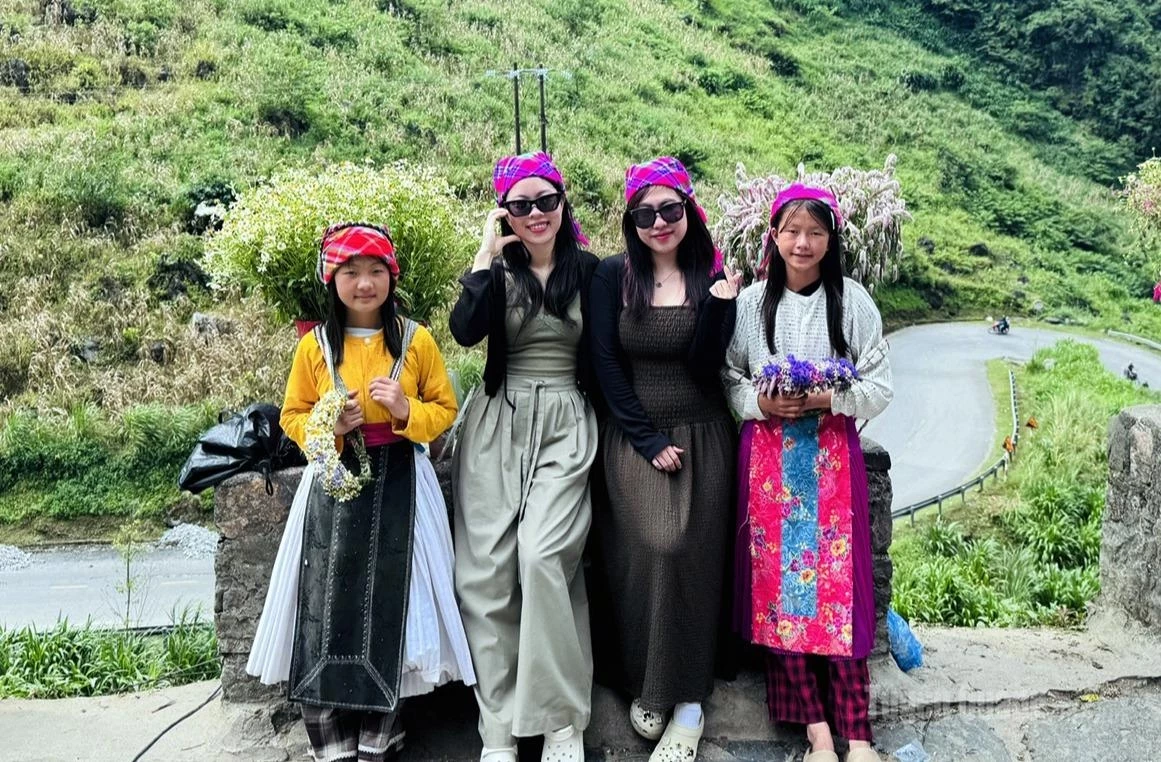 The innocent smiles of Mong ethnic children alongside visitors add vibrant cultural colors to their journey through the highland mountains and forests.