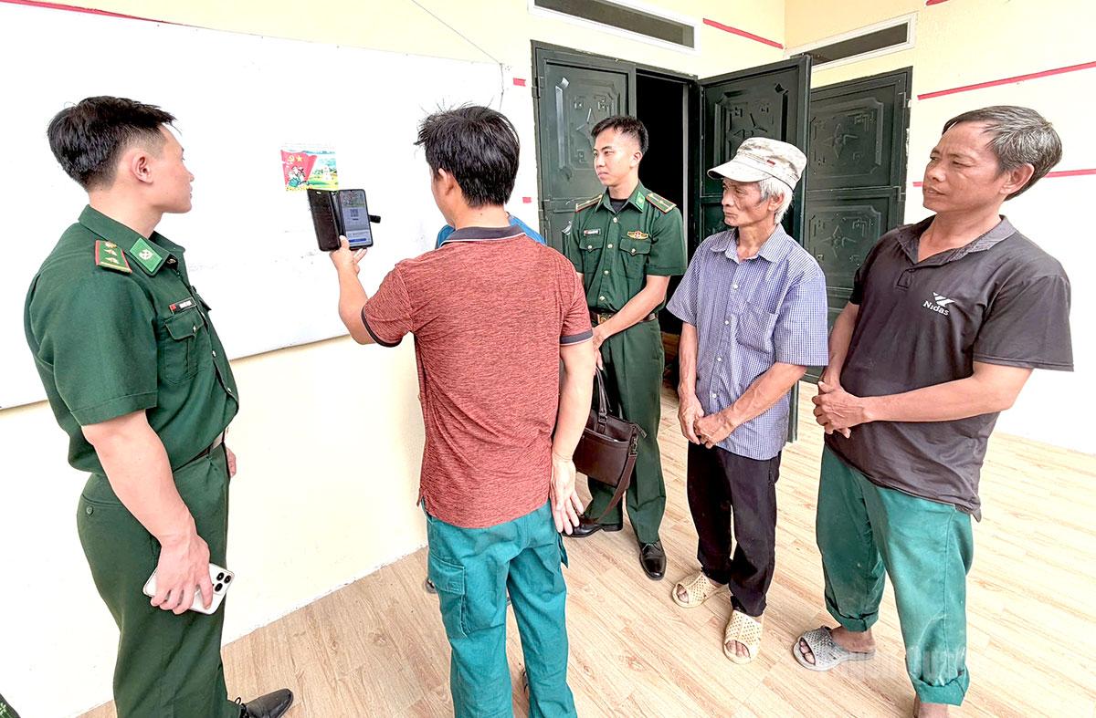 Cán bộ Đồn Biên phòng Cửa khẩu quốc tế Thanh Thuỷ hướng dẫn người dân sử dụng mã QR.