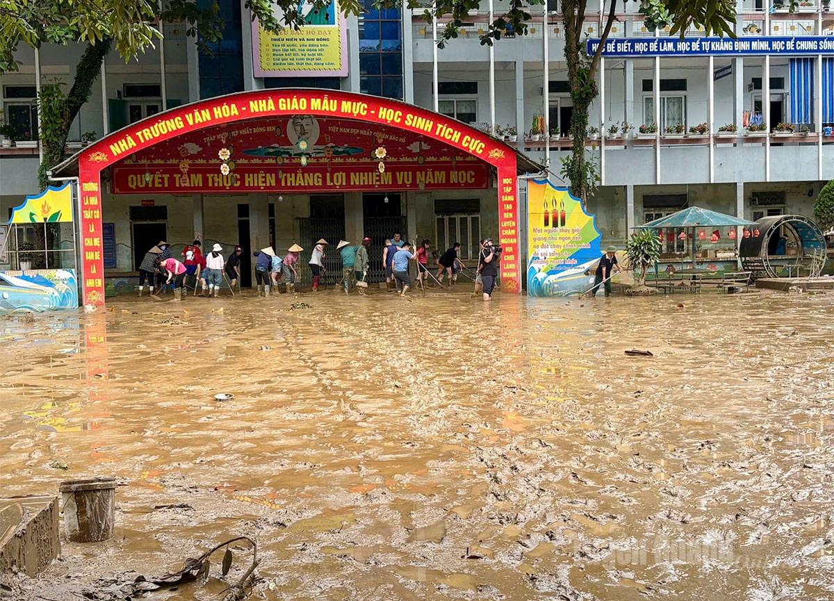 Nước rút bùn ngập sâu tại trường Tiểu học Quang Trung, phường Hà Giang 2. Ảnh Khánh Huyền
