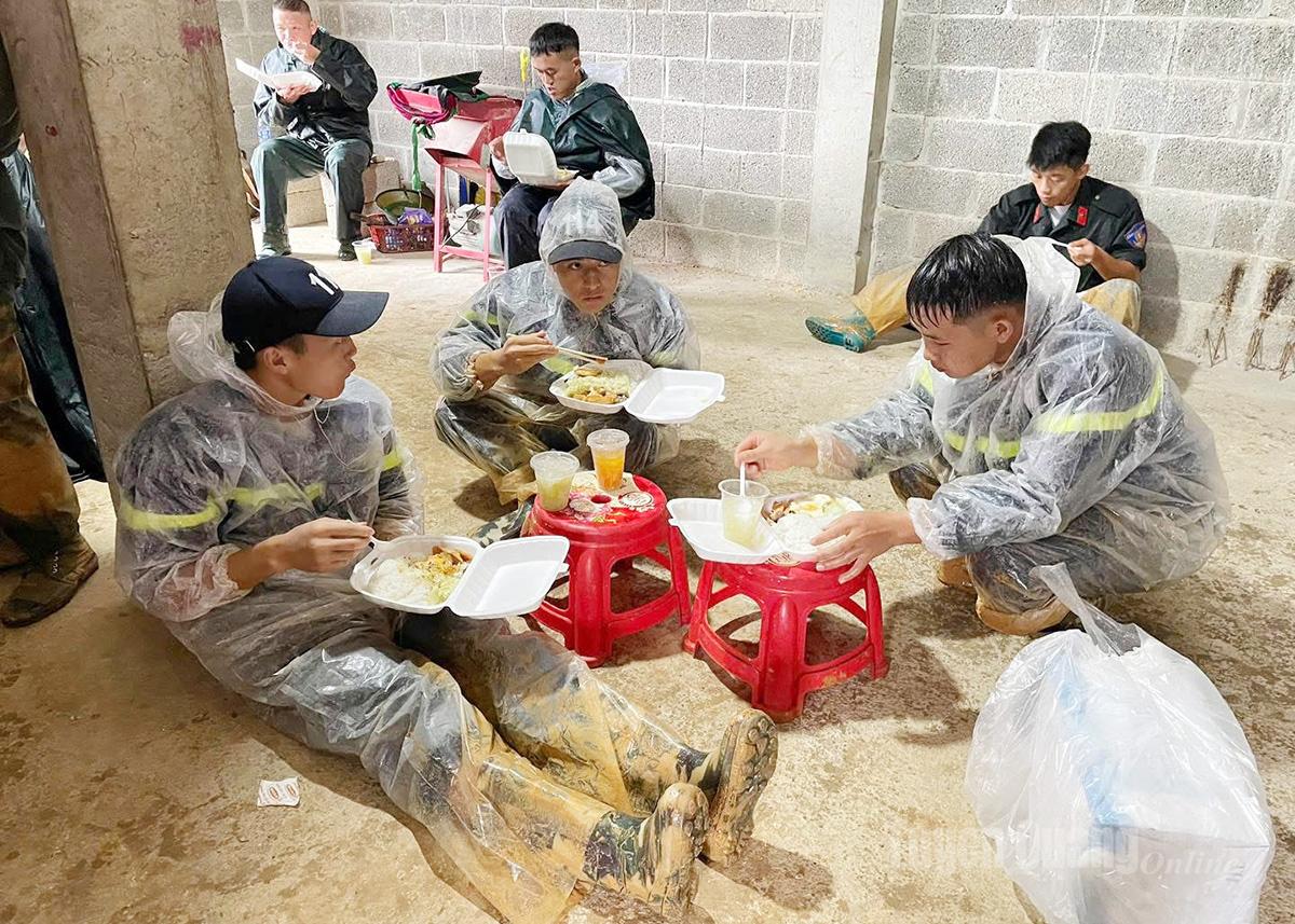 Bữa trưa khi quần áo còn lấm lem bùn đất của các chiến sỹ Cảnh sát cơ động.