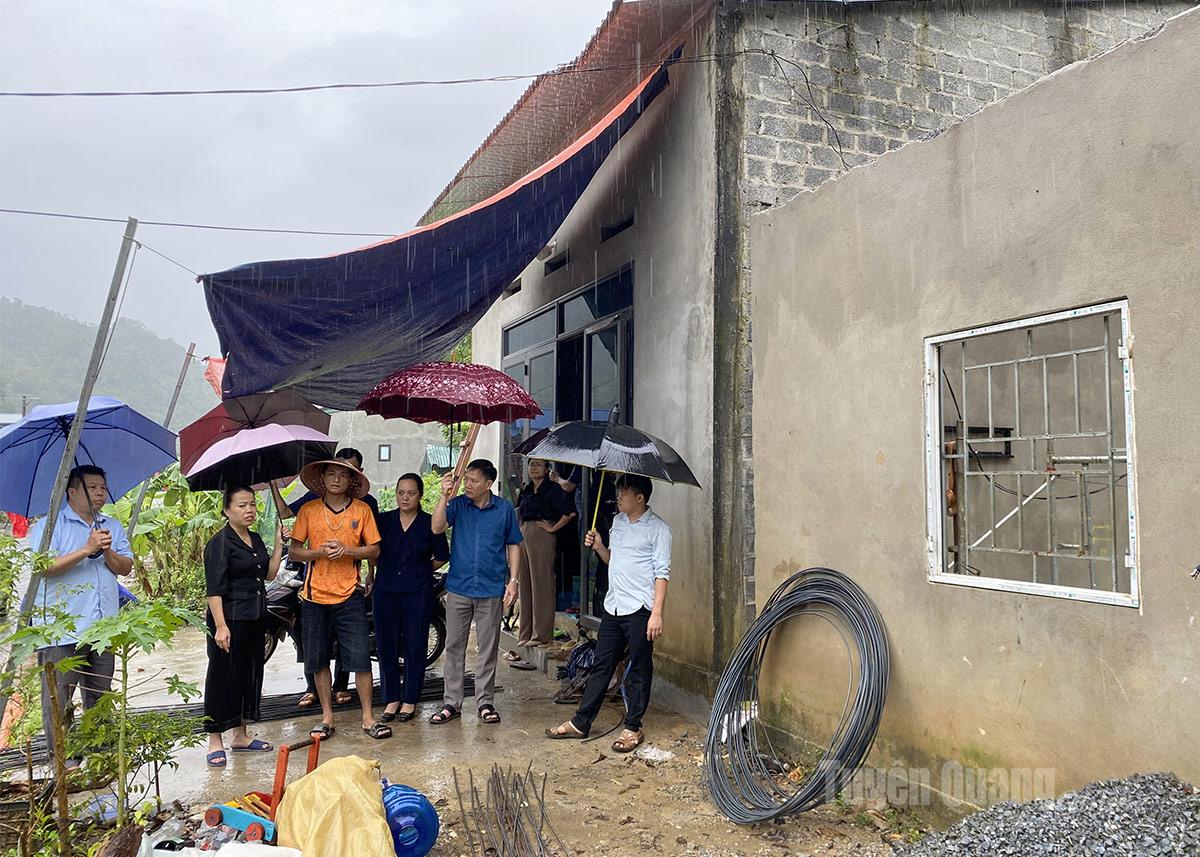  Đồng chí Lý Thị Lan kiểm tra thiệt hại gia đình bị tốc mái nhà.