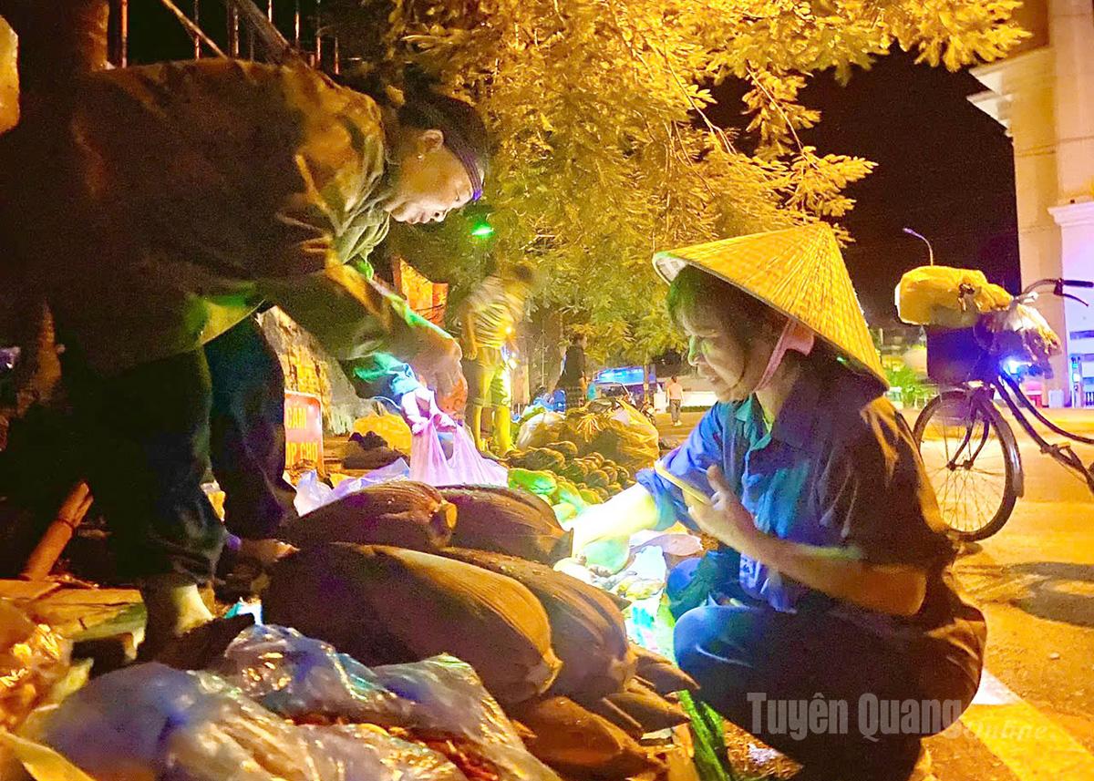 For convenience in trading, both sellers and buyers use personal lighting devices, creating a lively scene illuminated by many small lights.