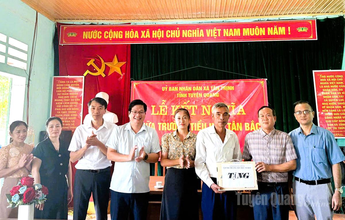 Lãnh đạo xã Tân Trịnh và cán bộ, giáo viên trường Tiểu học Tân Bắc trao máy tính cho thôn Lủ Hạ.