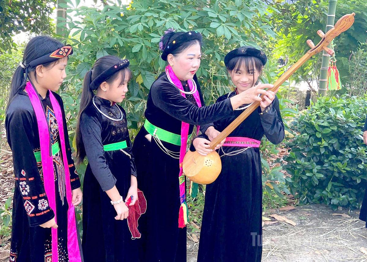 Bà Nguyễn Thị Chung, Chủ nhiệm CLB hát Then, đàn Tính xã Thái Sơn hướng dẫn các thành viên nhỏ tập đánh đàn Tính.