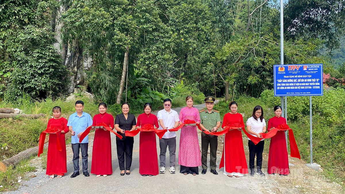 Các đơn vị tài trợ và lãnh đạo xã Minh Sơn cắt băng khánh thành mô hình dân vận “Thắp sáng đường quê - Giữ gìn an ninh trật tự”.
