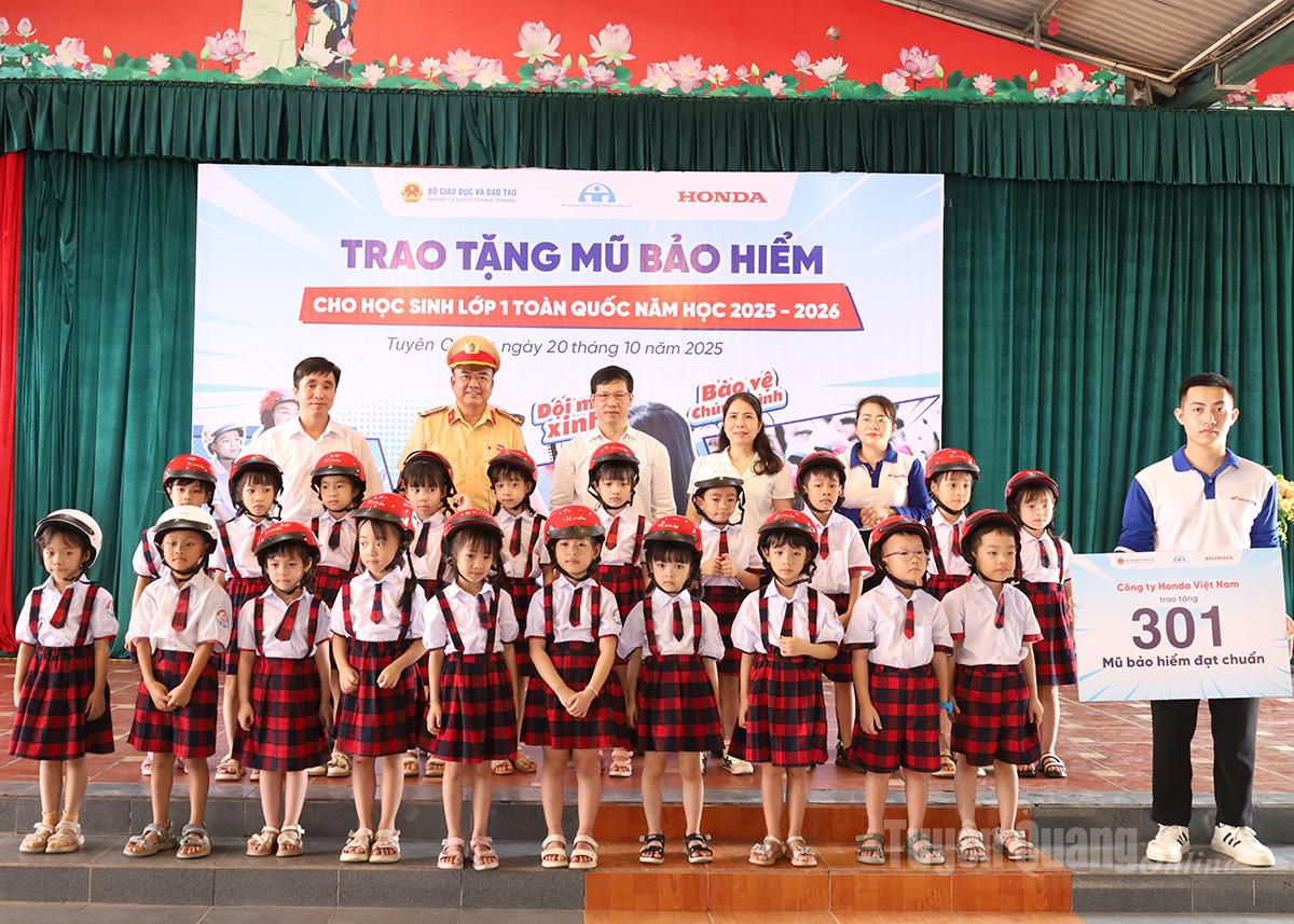 Các đại biểu tặng mũ bảo hiểm cho học sinh lớp 1.