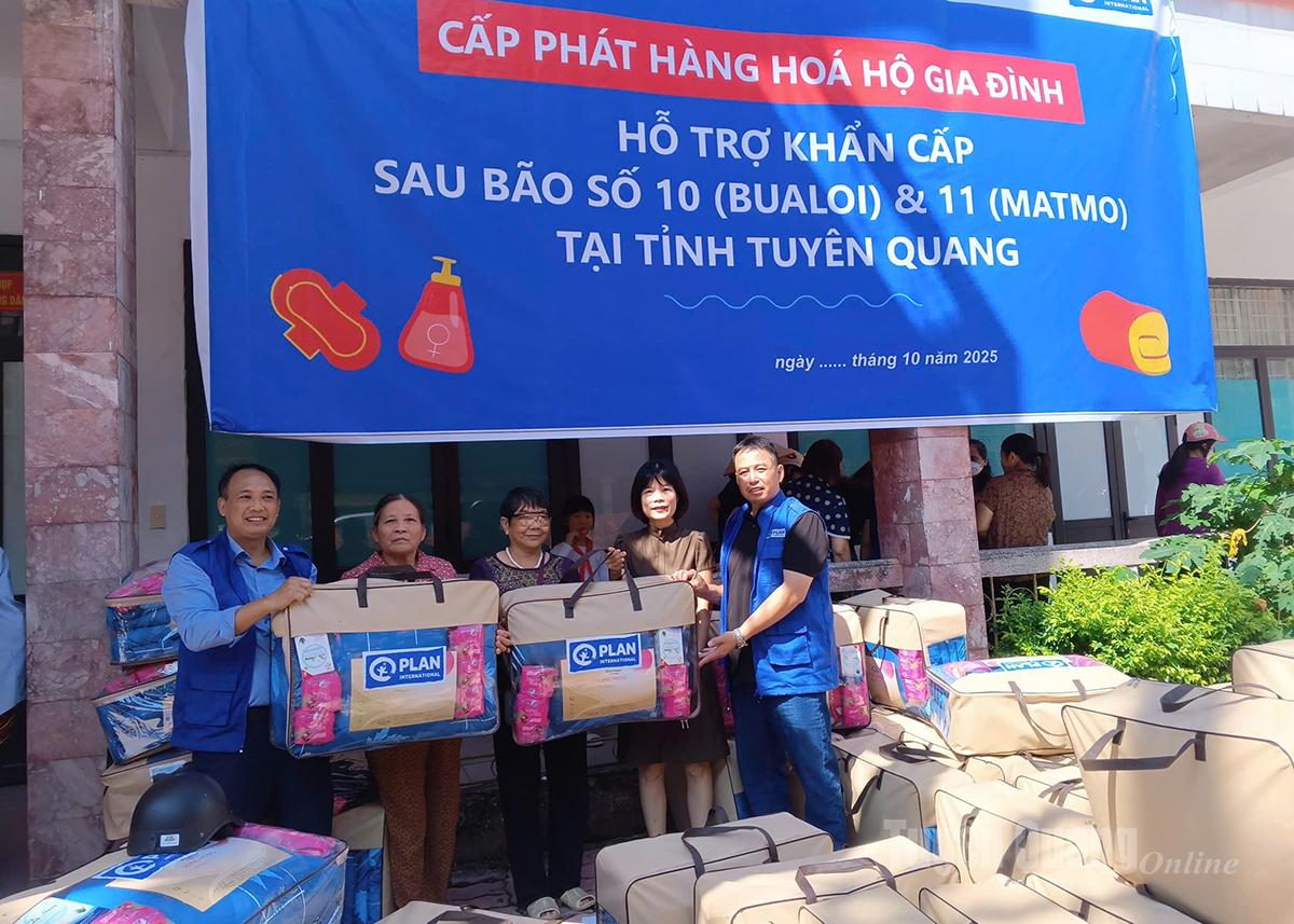 Đại diện Sở Ngoại vụ và Văn phòng Plan Tuyên Quang trao quà cho các hộ dân.