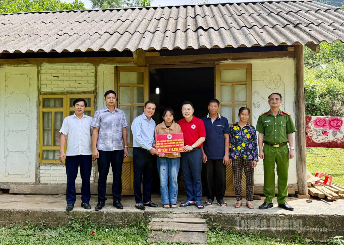 Lãnh đạo Hội CTĐ tỉnh và xã Tân Mỹ trao tiền hỗ trợ cho em Vàng Anh Thư.