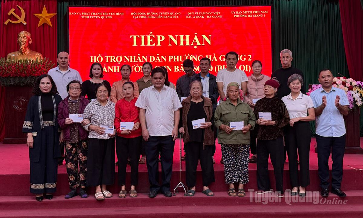Lãnh đạo Báo và phát thanh, truyền hình Tuyên Quang, nhà tài trợ và Đảng ủy, HĐND, UBND phường Hà Giang 2, trao tiền hỗ trợ cho người dân bị ảnh hưởng bão lũ.