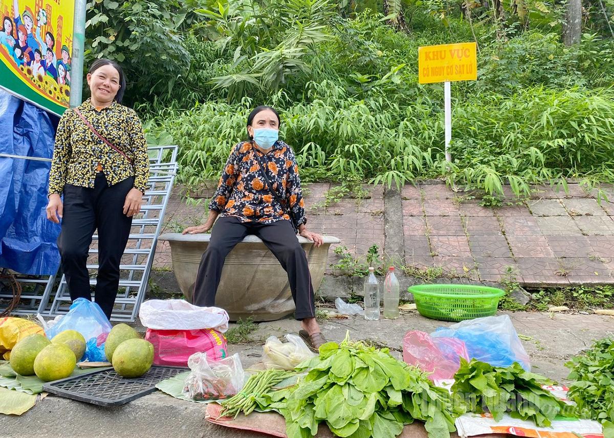 Người dân ngồi bán hàng ngay trước biển cảnh báo khu vực có nguy cơ sạt lở.