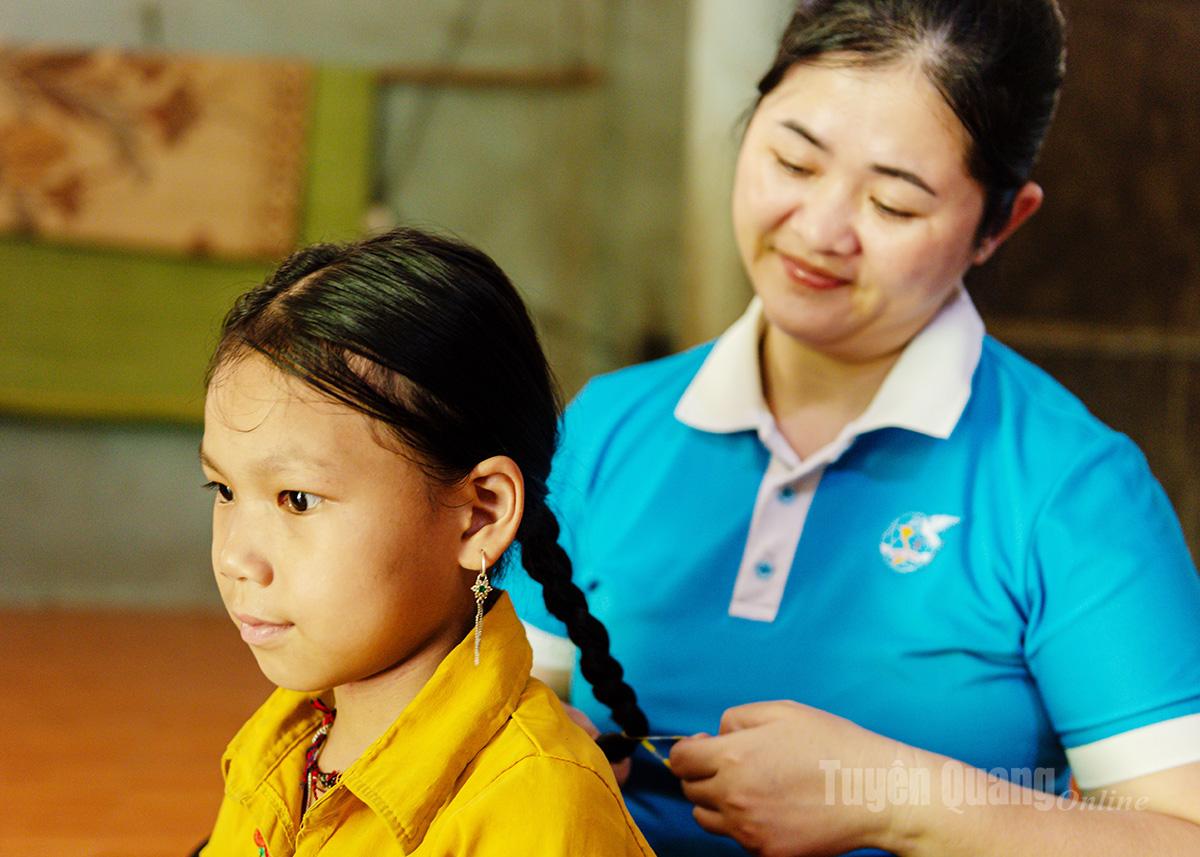 Ngày mẹ nuôi Hoàng Thị Thủy đến thăm, chị nhẹ nhàng ngồi tết lại mái tóc cho Hương.