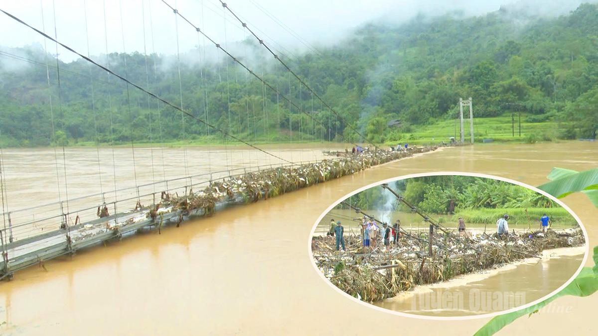 Cầu treo thôn Nà Vuồng, xã Bắc Mê các lực lượng tại chỗ và nhân dân đang dọn rác mắc lại để câu treo có thể đi lại thông suốt. Ảnh: Hoàng Long
