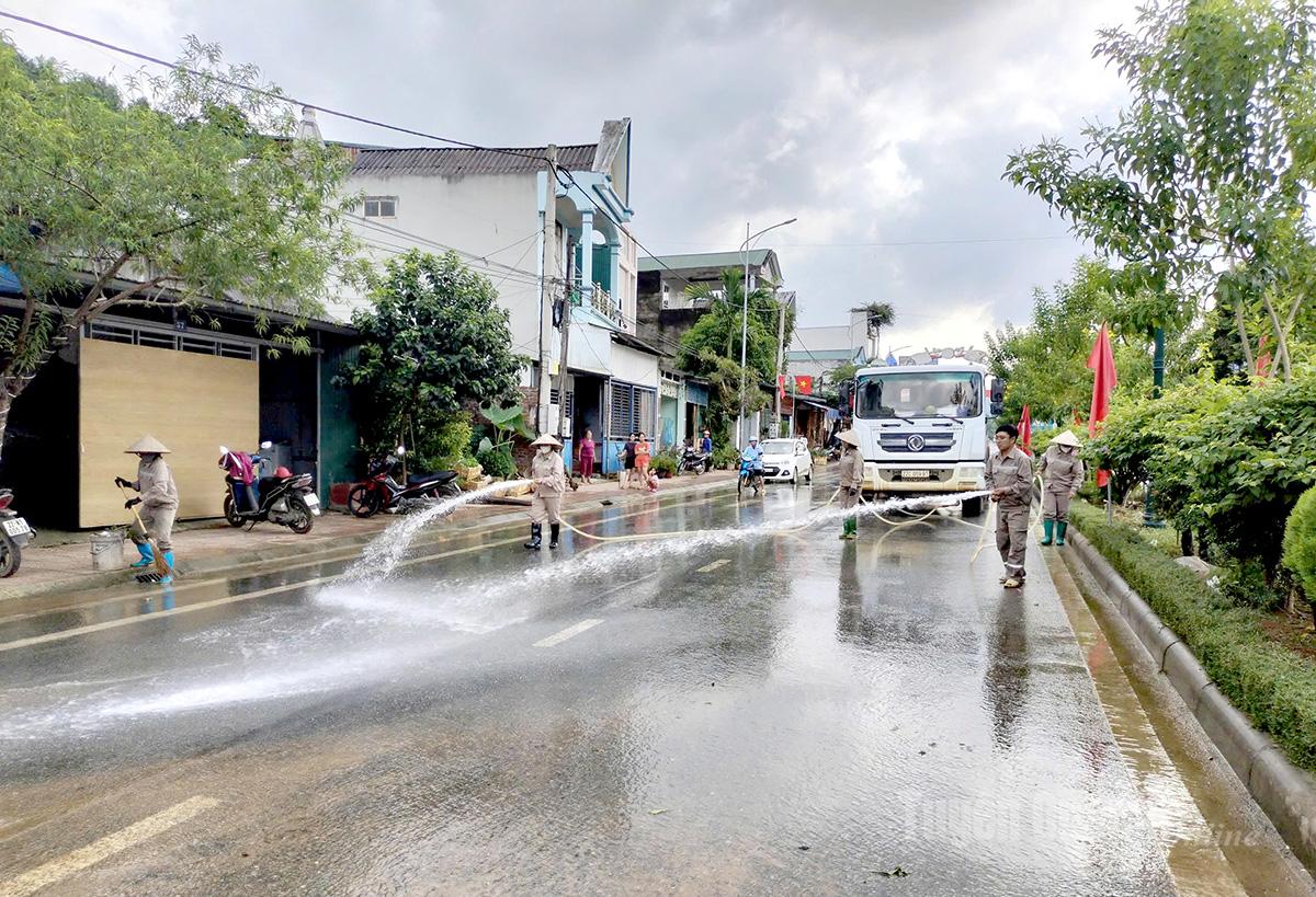 Công nhân Công ty cổ phần Tuyên Quang Xanh tham gia vệ sinh tuyến đường trung tâm xã Nà Hang sau khi nước lũ rút đi. Ảnh: Huy Hoàng