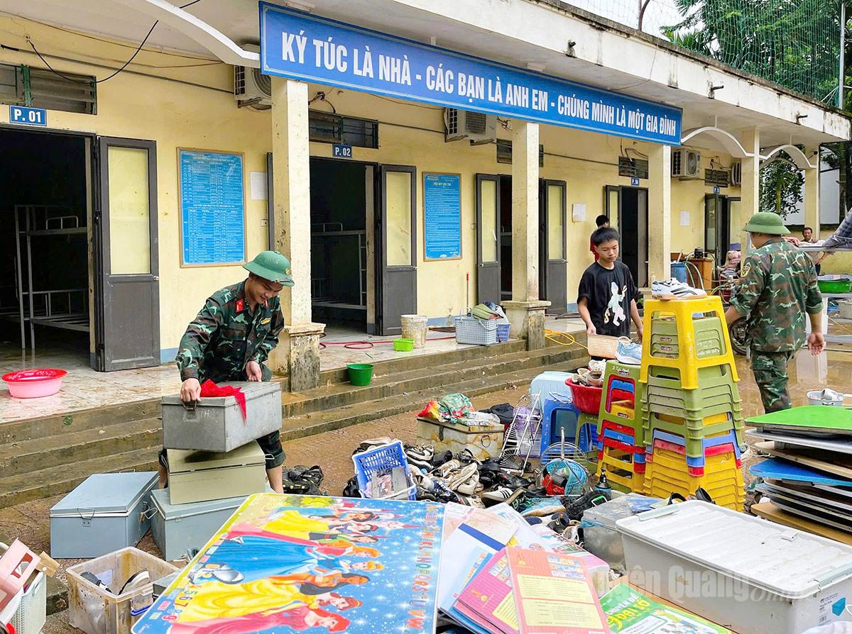 Cán bộ, chiến sĩ Ban Chỉ huy phòng thủ khu vực 2 - Vị Xuyên giúp Trường THCS Lý Tự Trọng dọn dẹp sau lũ. Ảnh: Mộc Lan