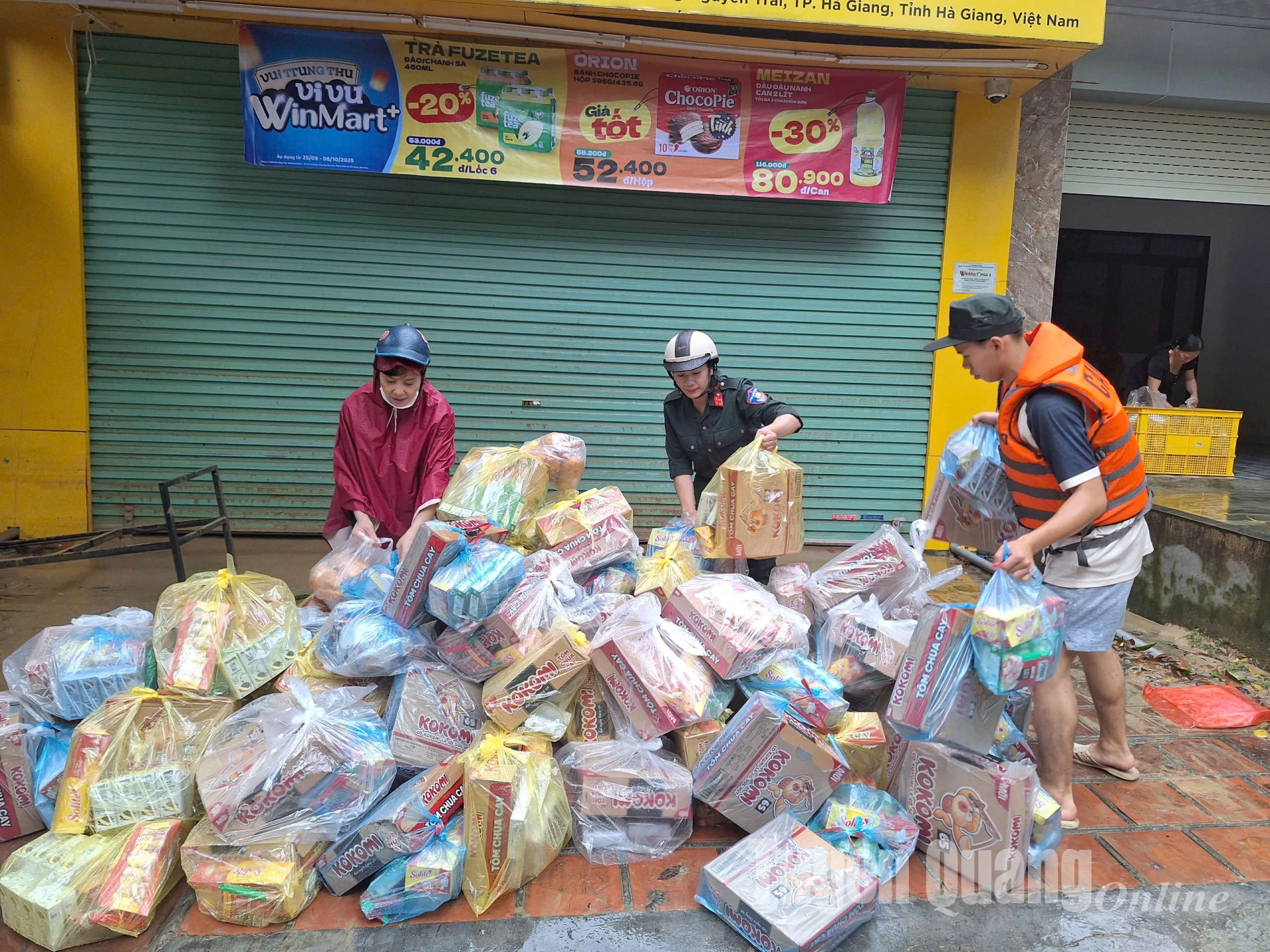 Lực lượng chức năng và các mạnh thường quân cùng hỗ trợ chuẩn bị các suất hỗ trợ trao cho người dân.