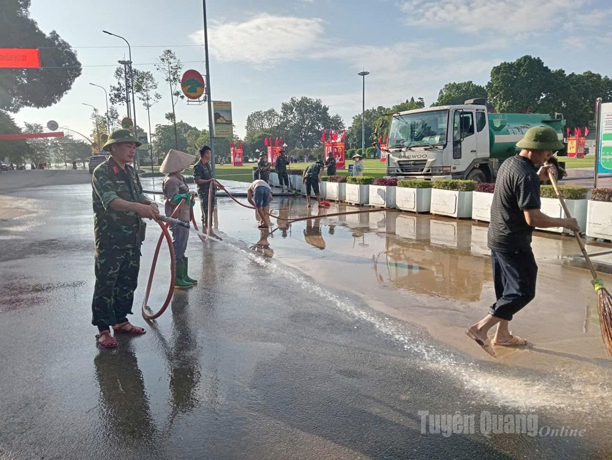 Cán bộ chiến sĩ Trung đoàn 247 hỗ trợ Công nhân Công ty cổ phần dịch vụ môi trường và quản lý đô thị Tuyên Quang dọn dẹp khu vực Quảng trường Nguyễn Tất Thành, phường Minh Xuân. Ảnh: Hoàng Ngọc
