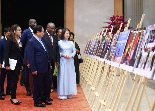 Prime Minister Pham Minh Chinh and South African President Matamela Cyril Ramaphosa view a photo exhibition on cooperation between the two countries. (Photo: VNA)