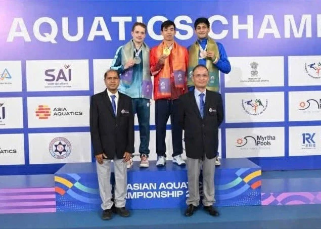 Huy Hoang stands at the centre of the podium with his Asian gold medal.