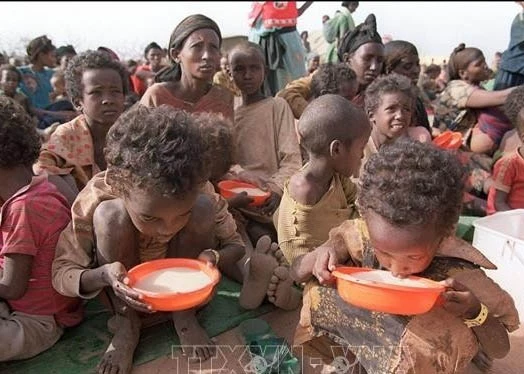 Two malnourished children drink milk from their plastic bowls at the Kebribeyah refugee camp in eastern Ethiopia (Photo: AFP/VNA)