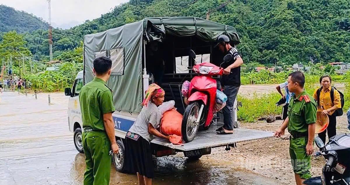 Lực lượng chức năng xã Minh Ngọc hỗ trợ người dân di chuyển qua các điểm cầu tràn trên địa bàn xã. Ảnh: Lý Thu
