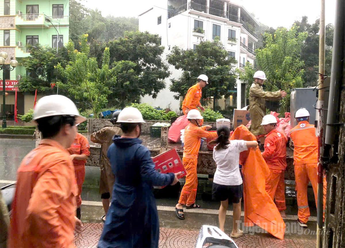 Công nhân Công ty Điện lực Tuyên Quang hỗ trợ người dân di chuyển đồ đạc. Ảnh: Đoàn Thư